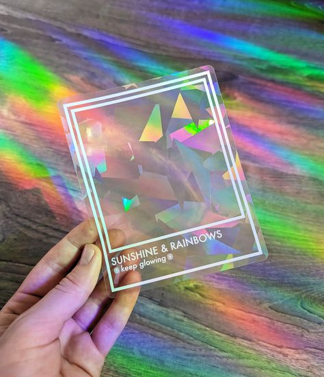 "Picture this: rays of sunlight streaming through your window, catching the prismatic magic of this rainbow maker. It's like having a mini dance party right on your glass! The moment direct, bright sunlight hits the sticker, it transforms sunlight into a kaleidoscope of mesmerizing hues. Looking for a delightful gift? Our Prismatic Rainbow Making Suncatcher Sticker is a fantastic present for friends, family, or anyone who could use a little extra cheer in their life. Birthdays, housewarmings, or just because... this sticker is sure to bring a smile to their face. Crafted with the utmost care, this 4\" x 5\" window decal is easy to apply and remove, leaving no sticky residue behind. It's durable too, ensuring that your rainbow-making companion will keep dazzling your days for years to come. Suncatcher Sticker Window, Cricut Suncatcher, Sun Catcher Sticker, Window Packaging, Sticker Minimalist, Fun Packaging, Suncatcher Sticker, Sun Catcher Window, Window Light