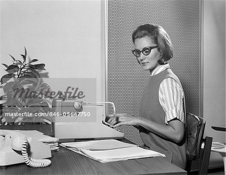 1960s SECRETARY TYPIST WEARING STYLISH EYEGLASSES USING MANUAL TYPEWRITER AT DESK 1960s Secretary, Vanishing Half, 1960s Fashion Women, Manual Typewriter, Sweet Charity, 1970s Women, Career Girl, Stylish Eyeglasses, Women Talk