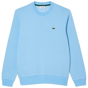 The new improved SH9608 crew sweat from Lacoste sports a classic fit and is crafted from a super soft organic brushed-cotton fleece with added recycled polyester for warm yet lightweight wear. Styled with a slightly tighter ribbed crew neck it's a strong revised cut for a new generation. Finishing this piece is the brands signature embroidered crocodile sewn onto chest.**Key Info:*** Classic fit, natural ease* Low-cut neck* Necktape in colours of Lacoste* Embroidered crocodile sewn onto chest* Brushed organic cotton fleece* 84% Cotton, 16% Elastane* SH9608 HBPSynonymous for creating the revolutionary first ever cotton Polo shirt, the Lacoste brand remains globally recognised for their iconic crocodile embroidered logo, and are renowned for their design innovation and signature French styli Lacoste Sweatshirt, Lacoste Sport, Blue Sweatshirt, Cotton Polo Shirt, Brushed Cotton, New Generation, Cotton Fleece, Casual Look, Low Cut