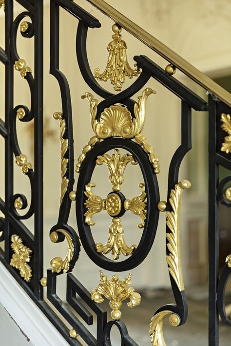 On the staircase in the foyer, the cast-iron and gold-leaf banister is a replica of one found at Le Petit Trianon. Big Bank Account, سلالم حلزونية, Iron Staircase Railing, درابزين السلم, Exterior Siding Options, French Palace, Stair Elevator, Wrought Iron Front Door, Cherry Wood Floors