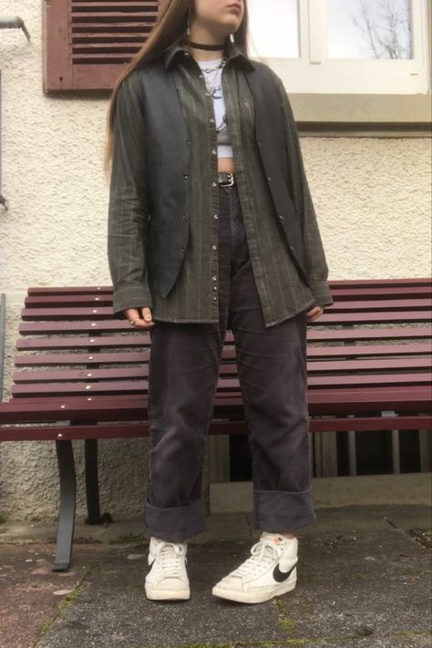 A mid-size person/girl wearing a wide black waistcoat, a thrifted dark olive green flannel under it, wide black corduroy pants, white Nike blazers and multiple crystal rings and bracelets. 	The person is also wearing multiple silver necklaces, one in form of a green crystal and another in form of a fairy  necklace, a black bead necklace, a butterfly and a black lace choker. Androgynous Fashion Summer, Retreat Photoshoot, Fit Aesthetic Outfit, Earth Tones Fashion, Gilet Outfit, Jewelry Lace, Fit Aesthetic, Funny Clothes, Black Waistcoat