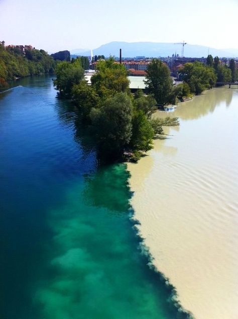 **Junction of two rivers Rhone and Arve rivers in Geneva, Switzerland. The river on the left is the Rhone, which is just exiting Lake Lehman. The river on the right is the Arve, which receives water from the many glaciers of the Chamonix valley before flowing north-west into the Rhone on the west side of Geneva, where its much higher level of silt brings forth a striking contrast between the two rivers. Incredible Pictures, Many Glacier, Two Rivers, Geneva Switzerland, Voyage Europe, Places Around The World, Mykonos, Geneva, Beautiful World