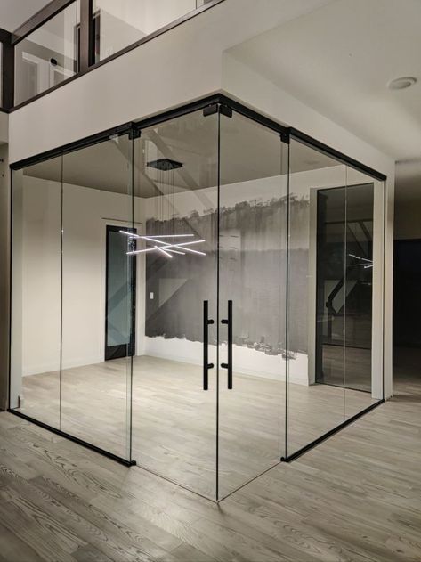 Glass partitions can be employed to create private offices in a corporate environment, define living areas in homes, or add a touch of elegance to retail spaces. The versatility of these designs makes them a popular choice for modern interior architecture.  #GlassPartition #InteriorDesign #ContemporarySpaces #ArchitecturalInnovation #TransparentLiving #OfficeDividers #ModernAesthetics #FunctionalDesign #OpenConceptLiving #InnovativeInteriors Home Gym Glass Wall, Home Gym With Glass Doors, Glass Gym Doors, Gym Glass Wall, Home Gym Glass Doors, Gym With Glass Wall, Home Office With Glass Walls, Glass Office Doors, Gym Basement