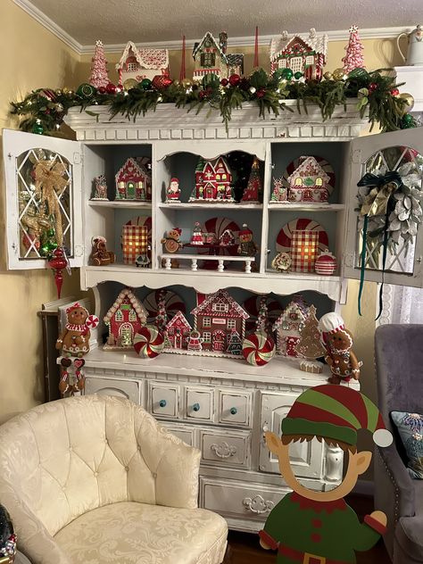 Christmas Village Display Kitchen Cabinets, Christmas Village Hutch Display, Christmas Cupboard Decor, Over The Cabinet Christmas Decor, Gingerbread House Display Ideas, China Cabinet Christmas Decor, Christmas China Cabinet Decor, Christmas Hutch Decorating Ideas, Hutch Christmas Decor