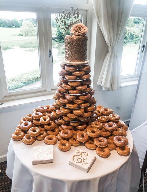 After looking at MANY donut cake pins on here, this was my creation last month for our wedding! Very pleased with how it turned out!  Doesn’t quite show in the pic but some also had edible rose gold and pink spray paint on them for a lovely glow! :)   Doughnut donut wedding cake Krispy kreme cake original glazed Krispy Kreme Wedding Cake Donut Tower, Doughnuts At Wedding, Wedding Doughnut Cake, Doughnut Cake Wedding, Wedding Cake Donut Tower, Donut Cake Wedding, Krispy Kreme Wedding Cake, Krispy Kreme Donut Cake, Donut Tower Wedding