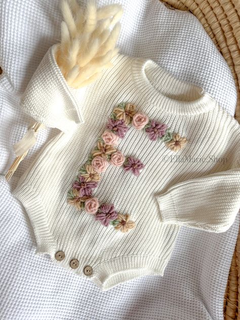 Our hand-embroidered floral initial romper is the perfect addition to your little one's wardrobe or a thoughtful gift for baby showers, baby reveals, or pregnancy announcements. Each romper is meticulously crafted with soft, breathable fabric to keep your baby comfortable all day long. The beautiful floral design adds a touch of whimsy and sweetness, making it a delightful outfit for any occasion. What makes this romper truly special is the custom embroidery of your baby's initial on the front. Baby Hand Embroidery Designs, Embroider Baby Clothes, Nursery Embroidery Ideas, Embroidered Baby Onesie, Summer Newborn Outfits, Baby Clothes Embroidery, Embroidered Kids Clothes, Embroidery Kids Clothes, Baby Embroidery Ideas