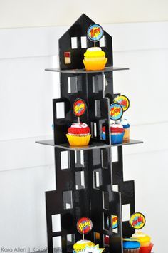 Love the city skyscraper cupcake holder! Modern Superhero themed birthday party by Kara Allen | Kara's Party Ideas | KarasPartyIdeas.com-19 Superhero Birthday Party Ideas, Incredibles Birthday Party, Superhero Girls Birthday, Pj Masks Birthday, Batman Birthday Party, Cupcake Stands, Batman Party, Avengers Birthday, Spiderman Party