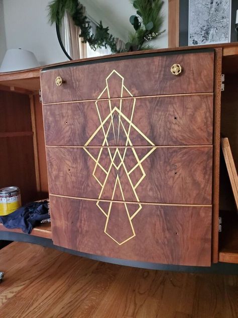 I purchased this buffet on my local Facebook marketplace in hopes to give it a new life and flip it. It was in great shape as far as the veneer, doors and hardware. But I had much more in store for this piece I took of the top hutch part as well as the doors and sanded them down with a sand paper grit 120,220 and 320. I made some sketches and decided to go with option 1. And expose as much of the amazing wood grain as possible. I added a cool art deco design on the front which Pinstripe Furniture, Art Deco Cabinet Makeover, Art Deco Wood Furniture, Art Deco Buffet Makeover, Art Deco Dresser Makeover, Dresser Repaint, Art Deco Furniture Makeover, Cupboard Upcycle, Art Deco Wall Paper