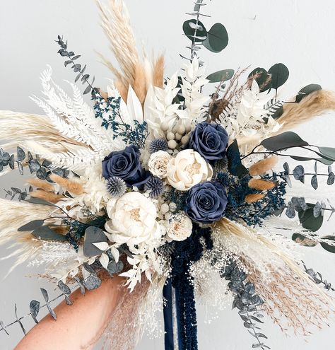 Dried everlasting bouquet including pampas grass, preserved roses, hydrangea, silver Brunia, bunny tail grass, sola wood flowers. Perfect bridal bouquet, bridesmaids bouquet, or place in vase for home decor. Hand tied with silk chiffon ribbon.  -Large Bouquet is approximately 16" (shown) -Medium Bouquet is approx 14" -Small Bouquet is approx 8"  *Each arrangement is handmade to order and we try our best to ship out within the listed processing time. If you need your item sooner, please message m Rustic Bridal Bouquet Dried Flowers, Magnolia And Pampas Bouquet, Blue And Wedding Color Schemes, Dark Blue Champagne Wedding, Cascading Winter Bouquet, Wooden Wedding Flower Bouquets, Navy Blue Wedding Theme Rustic, Cat Tail Floral Arrangements, Rose Gold And Navy Blue Wedding Theme Flowers