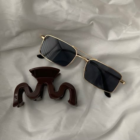 Gold vintage inspired sunglasses laying on white bedding with a chocolate brown hair claw Vintage Aesthetic Accessories, Aesthetic Sunglasses Vintage, Vintage Sunglasses Aesthetic, Hair Claw Aesthetic, Claw Aesthetic, Cool Sunglasses Aesthetic, Sunglass Aesthetic, Shades Aesthetic, Indie Sunglasses