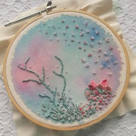 Picture of an embroidery hoop, background made in watercolor in pastel blue, green and pink, sea creatures made with thread and beads, mostly green and pink. Under The Sea Embroidery Ideas, Embroidery Under The Sea, Sea Theme Embroidery, Watercolor With Embroidery, Under The Sea Textiles, Watercolor And Embroidery On Fabric, Embroidery And Watercolor, Embroidery With Beads Ideas, Sea Embroidery Ideas