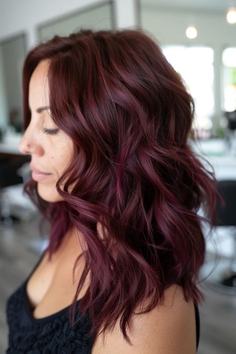 Woman with wavy, shoulder-length burgundy hair in a salon setting. Wine Red Hair With Bangs, Maroon Hair With Highlights, Burgundy Hair Highlights, Cool Red Hair, Burgundy Hairstyles, Burgundy Hair With Highlights, Red Hair With Bangs, Wine Hair Color, Red Hair Color Ideas