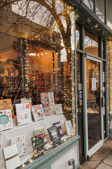 The cozy storefront of Curious Iguana. Blue trim, books in the window, and twinkling lights. Small Cozy Bookstore, Indie Bookstore Aesthetic, Small Bookstore Design, How To Open A Bookstore, Opening A Bookstore, Cozy Bookshop Aesthetic, Library Cafe Design, Bookstore Lighting, Bookstore Layout