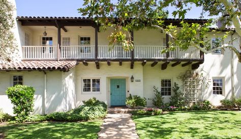 Blue front door on a white plaster Spanish style house with brown accents via House of Turquoise: Charmean Neithart Interiors Hacienda Balcony, Ranch Style House Exterior, Monterey Colonial, Monterey Style, Spanish Exterior, Spanish Revival Home, Mediterranean Exterior, Spanish Bungalow, Home Styles Exterior