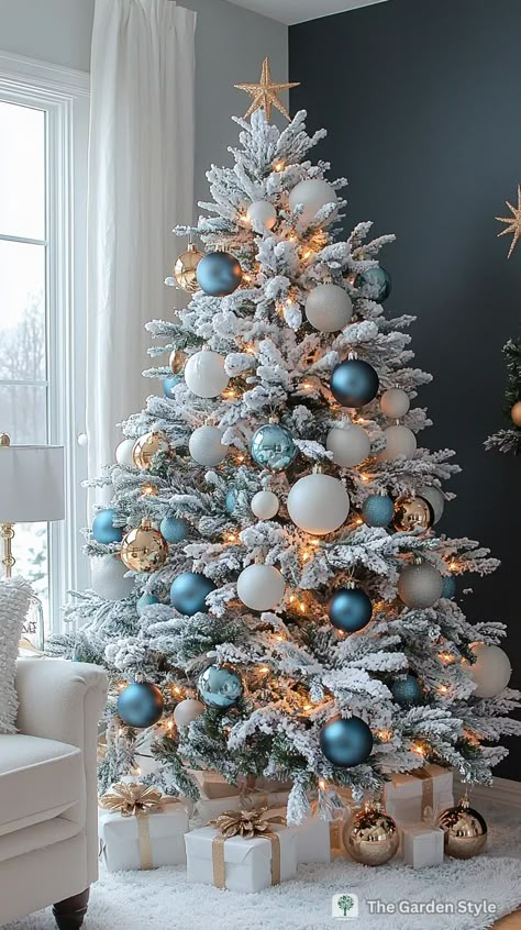 80+ Stunning Flocked Christmas Tree Decorating Ideas - The Garden Style Flocked Tree Blue Ornaments, Flocked Decorated Christmas Tree, Blue And White Christmas Tree Decor, Christmas Tree 2024 Trends Decoration, Christmas White Tree Ideas, Candy Christmas Tree Ideas, Snow Christmas Tree Ideas, Light Blue Christmas Tree Decorations, White Christmas Tree Ideas Color Schemes