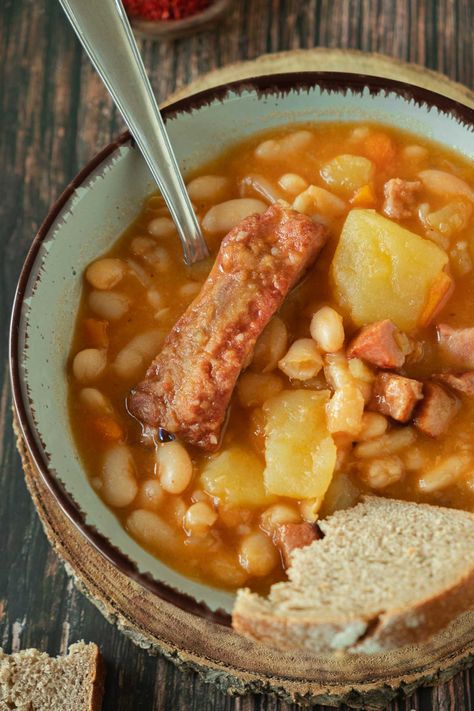 A bowl full of grah stew with white beans, potatoes, carrots, and smoked pork ribs. Dutch Oven Corned Beef, Mediterranean Beef Stew, Healthy Bacon Recipes, Dutch Oven Dinners, Pot Roast Sandwiches, Homemade French Onion Soup, Oven Dinners, Beans Potatoes, Smoked Pork Ribs