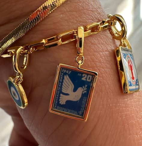 A symbol of peace in blue. A vintage Bulgarian postage stamp from 1947. Will be a perfect addition to a necklace or bracelet stack. Customizable Charms for Endless VersatilityAll our charms feature an innovative open and close mechanism, allowing you to easily move them between necklaces and bracelets for a truly personalized look. - This jewelry is waterproof, built to keep up with your everyday life. Whether you're showering, working out, or swimming, it won't fade. Good Necklace Stack, Where To Buy Jewelry, Protective Charms, Symbol Of Peace, Necklaces And Bracelets, Jewelry Accessories Ideas, Jewelry Lookbook, A Necklace, Postage Stamp