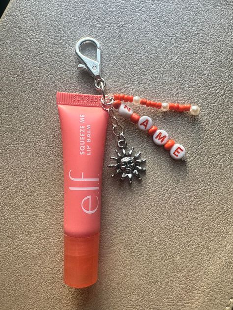 Join in on the cute and trendy lip balm keychain! This product is reusable and can be customized personally to you.  1. Choose which flavor lip balm you would like, or opt out and choose "keychain only" if you have your own lip balm you want to add it to.  2. Choose the pendant you would like. (More to come soon!)      - Sun       - Moon       - Cactus       - Balloon Dog       - Sport ( Softball, Baseball, Tennis, Football, Basketball, Soccer, and Volleyball, with corresponding colors) 3. Include your name for the keychain. Cute Diy Crafts For Best Friends, Lip Balm Keychain Aesthetic, Preppy Keychain Ideas, Home Made Keychain Ideas, Lip Gloss Keychain Ideas, Things To Get Friends For Christmas, Charm Crafts Diy Projects, Lip Balm Charm Keychain, Lipgloss Keychain Ideas