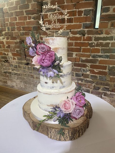 3 tier semi-naked wedding cake decorated with stunning purple & pink fresh flowers and personalised topper Lavender And Pink Wedding Cake, Lavender Themed Wedding Cake, 3 Tier Cake With Flowers, Pink And Purple Wedding Cake, Wedding Cake With Fresh Flowers, Wedding Cake Purple Flowers, Strawberry Wedding Cakes, Wedding Cake Peach, Pink Purple Wedding