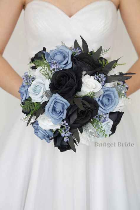 This magnificent rounded brides’ bouquet is crafted using black, dusty blue, steel blue and light blue roses of the highest quality. This elegant bouquet is sure to leave a lasting impression. The delicate silver accents in this collection, create a bright and dazzling arrangement that is sure to turn heads. With a mixture of black foliage and greenery this bouquet is sure to make a statement. All of our bouquets are a wonderful option for destination weddings, as they can be bought in advance a Blue Black And White Bouquet, Midnight Blue Themed Wedding, Powder Blue And Black Wedding, Blue And Black Flowers Bouquet, Slate Blue And Black Wedding, Black And Blue Wedding Bouquet, Black Blue And Silver Wedding, Dusty Blue Black Wedding, Black And Light Blue Wedding Theme