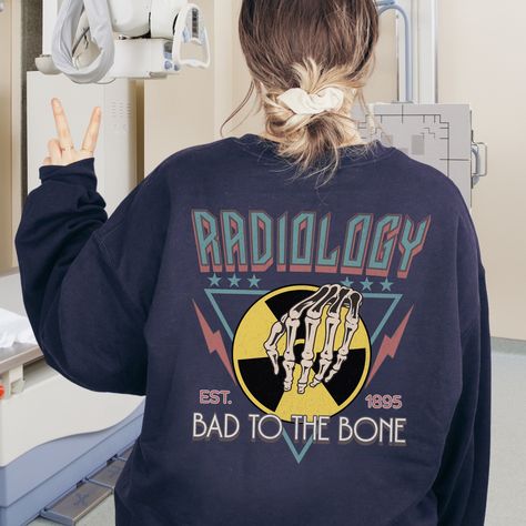 🩻(DESIGN PRINTED ON BACK) Show your support for the important work of Radiology professionals with this fun sweatshirt! Find unique Radiology apparel and gifts here in our shop. THIS DESIGN IS PRINTED ON THE BACK AND FEATURES WEATHERED/DISTRESSED DETAILS AND PRINTED ON FRONT AND BACK. FINAL PRINT COLORS MAY APPEAR SLIGHTLY DIFFERENT FROM PHOTOS VIEWED ON COMPUTER MONITORS AND CELL PHONE SCREENS. ⚡ Printed on the most popular Unisex Sweatshirt, the Gildan 18000 is 50% Cotton / 50% Poly. The soft fleece lining makes it super Comfy and is sure to become your new favorite! ⚡ This Unisex Sweatshirt fits like a Men's on Women, but is not overly large. ⚡ This Sweatshirt is printed with high quality, non-toxic Direct To Garment Digital Inks for beautiful and natural results! ⚡ WASHING INSTRUCTION X Ray Tech Tattoo, Radiology Technologist Week, Radiology Apparel, Rad Tech Week, Radiology Shirts, Radiologic Technologist, Radiology Student, X Ray Tech, Radiology Technologist