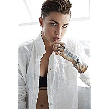 Another image of Ruby Rose portraying masculinity. She looks like she should be on the cover of GQ with the way she is dressed and posing. She is wearing what looks like a men's dress shirt while giving a smoldering look to the camera. Women typically look seductive in different ways. But Ruby Rose is giving a more masculine vibe with the way she is holding her chin and looking into the camera. Ruby Rose Model, Kate Kane, The Veronicas, Androgynous Women, Rosé Hot, Rosé Aesthetic, Rose Pictures, Androgynous Fashion, Tattoo Girls