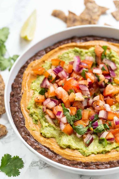 This healthy refried bean dip is made with five simple layers including a homemamde guacamole, homemade vegan queso, quinoa and refried beans. Bean Dip Healthy, Healthy Bean Dip, Vegan Queso Dip, Vegan Refried Beans, Refried Bean Dip, Dip Healthy, Refried Bean, Bean Dip Recipes, Vegan Queso