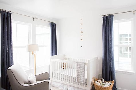 Amazing boy's nursery features a white traditional crib flanked by windows dressed in dark blue linen drapery panels facing a modern grey glider illuminated by an antique brass floor lamp. Blue Linen Curtains, Nursery Floor Lamp, Eclectic Modern Living Room, Nursery Curtains Boy, Transitional Nursery, Modern Grey Living Room, Navy Blue Curtains, Contemporary Nursery, Curtains Living Room Modern