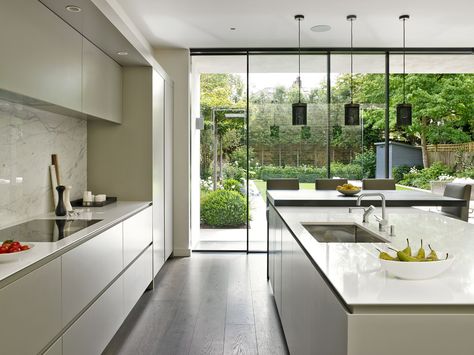 Sleek, minimalist, modern kitchen design in Wandsworth with handle-less cabinets. Large island with integrated sink and pendant lighting. Sliding glass wall looking out to landscaped patio and garden. Small Modern Kitchen Design, Model Dapur, Small Modern Kitchens, Interior Design Minimalist, Kitchen Design With Island, Decor Ikea, Classic Kitchen, 아파트 인테리어, Kitchen Extension