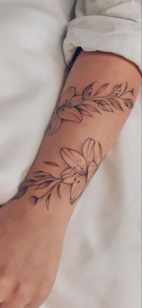 Lily Tattoo With Vines, Lily Wrap Around Wrist Tattoo, Flower Twist Arm Tattoo, Tiger Lily Tattoo Forearm, Lilly Wrist Tattoos For Women, Lily Flower Vine Tattoo, Rose Arm Wrap Tattoo, Simple Arm Wrap Tattoos For Women, Flower Tattoos Wrap Around Arm