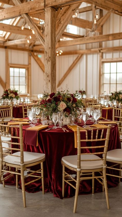 This breathtaking barn reception features rich burgundy velvet tablecloths, gold Chiavari chairs, and warm floral arrangements of deep red and blush roses with lush greenery. The romantic ambiance is enhanced by soft candlelight and rustic wooden beams, creating a perfect balance of elegance and coziness for a fall or winter wedding. 🍷✨ Gold Wedding Reception, Gold Chiavari Chairs, Barn Reception, Chiavari Chairs, Wooden Beams, Burgundy And Gold, Blush Roses, Rustic Elegance, Deep Red