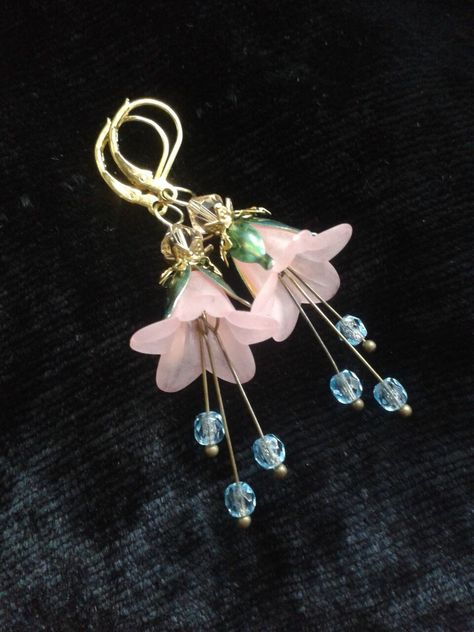 Pink bell flower earrings with green golden leaves holding them and pearl studded stamens dangling down from within. A lovely elf fairy jewelry gift for romantic women and, a garden lover! The leaves in gold green are handpainted by me, with aquamarine beads on the stamens, the earwires handmade by me. These ANNALEAS FINEST dangles were created with Swarovski® crystals. Make sure you visit my shop! https://www.etsy.com/shop/AnnaleasFinest?ref=seller-platform-mcnav here: Flower Petal Jewelry, Fairytale Earrings, Elf Jewelry, Lucite Flower Earrings, Pink Flower Earrings, Elf Fairy, Flower Earrings Gold, Lucite Jewelry, Flower Dangle Earrings