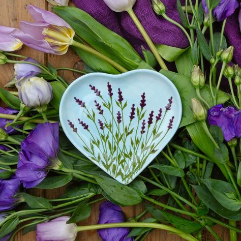 This Lavender heart shaped plate is hand painted with painted in pale blue with lavender flowers. It has a multitude of possible uses - for jewellery on the dressing-table, for biscuits at a tea party or as a matching plate for the Beach Huts egg cup. Small Heart Shaped Plate: 13cm x 12cm This will be beautifully packaged in a special brown cardboard box and tied up with coloured string. One of my personally designed gift tags will be attached, on which you can write your own message, or I can a Heart Shaped Plate, Heart Shaped Dish, Heart Plate, Diy Pottery Painting, Heart Dish, Lavender Heart, Pottery Painting Designs, Tanah Liat, Keramik Design