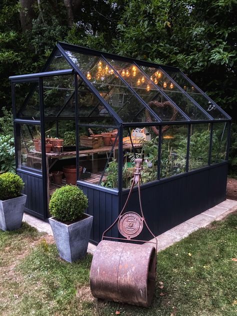 Greenhouse In Garden Design, Small Black Greenhouse, Small Greenhouse Vegetable Garden, Greenhouse Patio Porches, Backyard Greenhouse Aesthetic, Glasshouse Garden Ideas, Yard With Greenhouse, Chandelier In Greenhouse, Black Frame Greenhouse