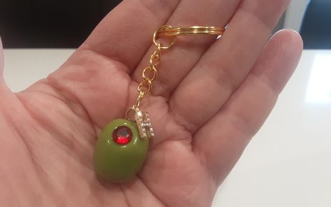 Personalized Handmade Martini Olive Keychains. Choose your size of Olive and whether you would like a red clay or faux gemstone center. Enter initial choice in Personalization Box. These olives are handcrafted by yours truly💝  Large size olive with fake gemstone is pictured on keychain. Once I have attached initial, it can't be removed. Message me with any special requests. Are you looking for the assortment of olives? They Are Here:  https://www.etsy.com/ca/listing/1337501454/handmade-miniature-olivesgreen-olives?click_key=f39b3a178403a6c33356d70306af87fa3054373d%3A1337501454&click_sum=46bcaca6&ref=shop_home_active_1&crt=1&sts=1 As they are handmade, each olive may differ from the next. (Color may differ from monitor to monitor and from each batch of color I mix ) Shipping Within Canada Unique Key Chain, Unique Gifts For Friends, Fun Keychains, Cool Keychain, Trendy Gifts For Women, Small Gift, Mini Gifts, Gifts For Mother In Law, Mom Gifts