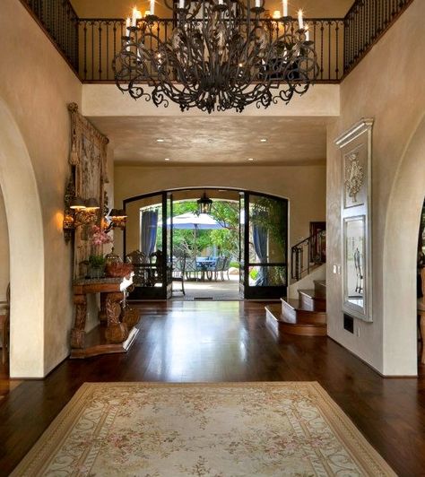 tuscan entry  What a chandelier! Modern Tuscan Chandeliers, Tuscan Entryway, Tuscan Hallway, Tuscan Front Door Entryway, Tuscan Villa Interior Decor, Tuscan House 2000s Aesthetic, Italian Villa Interior Design, Tuscan Chandelier, Tuscan Homes Interior