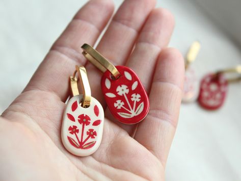 These charming double-sided ceramic earrings feature a striking combination of white and red hues. Handcrafted with meticulous care, they showcase an intricate floral pattern that adds a touch of ethnic elegance. Perfect as a thoughtful wedding jewelry gift, these earrings are designed to complement any bridal ensemble, making them a memorable and cherished addition to her special day. 🔸 Material and Technique Handmade white clay beads, coated with glaze and author's painting, accessories of 18K gold-plated brass. 🔸 Size The length of the earring with the post is 5 cm (1.97 inch) The size of the beads is from 2.9  (1.14 inch) The weight of the earrings is 12g 🔸 Gift box  https://www.etsy.com/listing/1613070823/wooden-jewelry-box-for-gifts-accessories?ref=listings_manager_grid 🔸 Recomme Sculpey Clay Jewelry, Clay Beaded Earrings, Baked Clay Earrings, Porcelain Earrings Ceramic Jewelry, Red Polymer Clay Earrings, Ukrainian Earrings, Gifts For Managers, Air Dry Clay Jewelry, Clay Earring Ideas