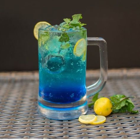 Blue Lagoon Drink Recipe, Blue Mojito, Mojito Mocktail, Party Punch Recipes, Blue Drinks, Jungle Juice, Peach Juice, Party Punch, Drink Photo