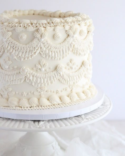 Vintage Vibes for the Big Day! How cute is this heart-shaped vintage-style wedding cake? Covered in ivory buttercream with delicate piping details, it's giving ALL the romantic, old-school vibes! Perfect for adding a little timeless charm to the big day! Who else loves a cake that looks this dreamy? Vintage Piping Wedding Cake, Romantic Wedding Cake Vintage, Simple Vintage Cake, Vintage Buttercream Cake, White Vintage Cake, 1 Tier Wedding Cakes, Vintage Style Cake, Wedding Cake Vintage, One Tier Cake