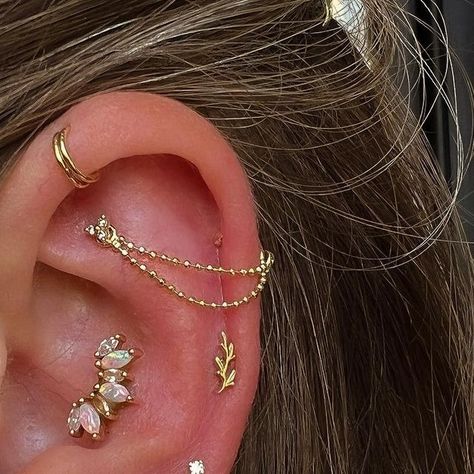 𝕹𝖎𝖈𝖔𝖑𝖊 • sacred gold • ʙᴠʟᴀ • GIA AJP on Instagram: "A really fun ear curation I have been working on with @jemmalouise1106 for years now! The latest change was replacing her industrial bar with a beaded chain connected to her faux rook, and stacking some rings in the other piercing. So much fun, I love this unique look! Thanks for trusting me on this Jemma! Jemma also has an Athena in her healed conch, a Tiny Amity in her fresh helix, and in her lobe a whole array of beautiful pieces. Mar Helix Piercing Styling, Conch Ideas Piercing, Ear Curation Ideas Gold, Faux Industrial Piercing, Ear Curation Gold, Dainty Industrial Piercing, First Lobe Piercing, Ear Piercing Ideas Conch, Gold Ear Curation