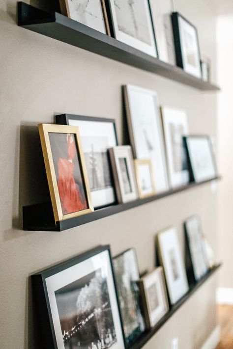 Black Photo Ledge, Leaning Frames On Shelf, Displaying Photos In Living Room, Family Pictures Display Ideas, Display Family Photos On Wall, Displaying Photos On Wall, Photo Ledge Display Layout, Photo Ledge Display, Decor With Photos