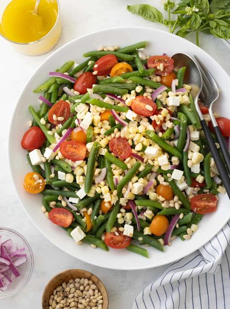 This easy cold green bean salad is the essence of summer. With tender green beans, sweet cherry tomatoes, golden corn and salty feta, it's colorful, flavorful, and easily made ahead. Dress at serving time with a classic Dijon vinaigrette. Cold green bean salad is like a sigh of relief on a hot summer day. It's terrific with grilled steak, chicken and ribs and an excellent way to showcase summer's fresh ingredients. Cold Green Bean Salad, Easy Italian Pasta Salad, Bacon Ranch Pasta Salad, Easy Summer Side Dishes, Salad With Tomatoes, Classic Pasta Salad, Green Bean Salad, Side Salads, Delicious Salad Dressings