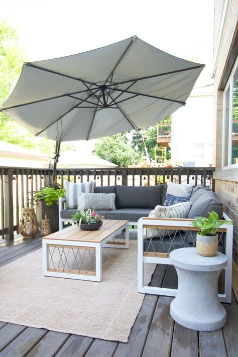 In love with our outdoor patio makeover! We used a large outdoor sectional, grounded it with a jute rug, and added in plenty of plants and flowers. Not to mention, a large umbrella for shade and string lights. #outdoorpatio #exterior #backyard #deck #patio Outdoor Deck Decorating, Outdoor Umbrella Stand, Deck Makeover, Patio Umbrella Stand, Diy Playbook, Small Deck Decorating Ideas, Outdoor Rugs Patio, Deck Decorating Ideas On A Budget, Patio Makeover