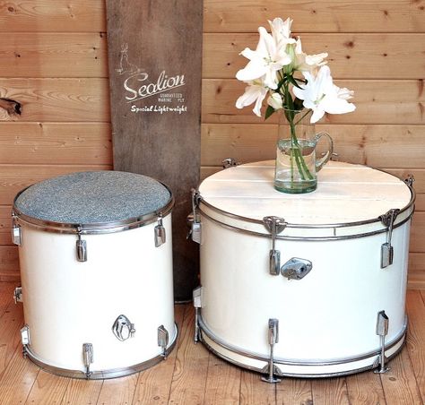 Rock Terrace bass drum coffee table and matching floor Tom drum upholstered seat, with a vintage wooden surfboard. www.rockterrace.co.uk Bass Drum Table, Drum Shelves, Repurposed Drums, Funky Stool, Drums Diy, Rock Terrace, Bourbon Lounge, Drum Lighting, Music Furniture