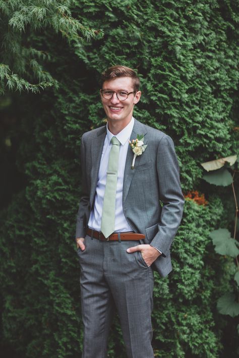 Groom in grey suit, brown belt, white shirt, and green tie Grey Suit Green Tie, Groomsmen Party, Sage Green Tie, Groom Suit Grey, Wedding Groomsmen Attire, Grey Suit Wedding, Suit Brown, Charcoal Gray Suit, Charcoal Suit