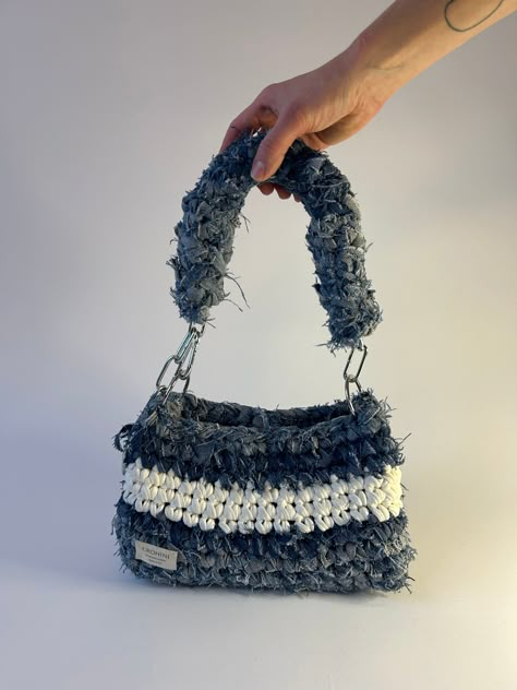 Up-cycled denim crochet bag in size M in light denim with white detailing. Sustainably handmade from up-cycled denim and 100% recycled yarn. Size: Length: 17 cm Width: 11 cm Height﻿: 15 cm Denim Yarn Crochet, Crochet Bags With T Shirt Yarn, Denim Yarn Projects, Yarn Bags Crochet, Denim Crochet Bag, Crochet On Denim, Crochet Repurpose, Crochet Bag Accessories, Handmade Bags Crochet