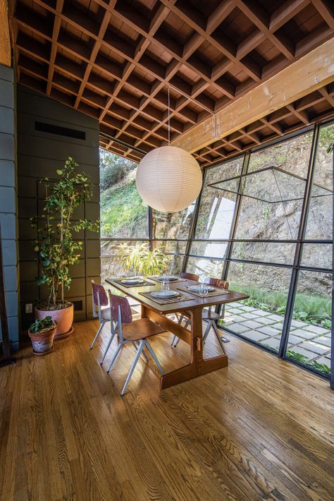 The slanted floor-to-ceiling glass walls were designed to mimic the surrounding slope. A Quincy Jones, Box Beam Ceiling, Quincy Jones, Floating Staircase, Laurel Canyon, Steel Beams, Glass Facades, Los Angeles Homes, Brick Fireplace