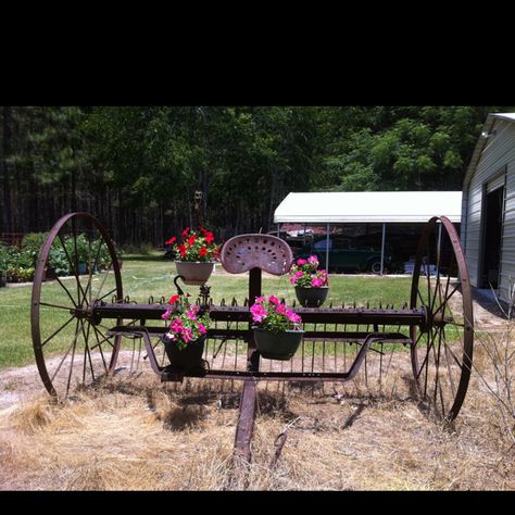 Would love to have an old hay rake for my yard. There is one for sale now I just need to convince the Hubby. I have got to find a way to mark our driveway so people can find the farm Antique Hay Rake Ideas, Antique Farm Equipment Landscape, Old Farm Equipment Decor Yards, Jupiter's Legacy, Farm Landscaping, Backyard Creations, Garden Wagon, Wagon Wheels, Old Farm Equipment