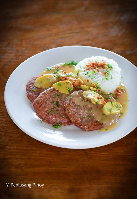 If, like me, and most other Filipinos, you enjoy eating tender, juicy meat with a strong umami flavor, you will surely enjoy this recipe. I love this Pinoy Burger Steak dish as it really simplifies the process of cooking up a great patty dish. How? It makes use of just a few essential ingredients to... Read On → The post Pinoy Buger Steak With Gravy appeared first on Panlasang Pinoy. Steak Gravy Recipe, Steak Gravy, Steak With Gravy, Burger Steak, Pork Chops And Gravy, Steak Dishes, Steak And Mushrooms, Beef And Rice, Gravy Recipe