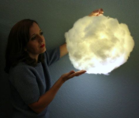 This pretty light is battery operated and safe to use.  It would make a great photo booth prop or party decor.  It would also look pretty in a nativity scene for the holidays.  These glowing cloud lights are so easy and inexpensive to make that you can have several in no time!   The diffused, soft light is beautiful in the dark!   Click through to my tutorial for a complete supply list and instructions.   The fluffy cloud is still cute when the lights are on!  It's a fun addition to a… Curtain Canopy, Cloud Lantern, White Paper Lanterns, Cloud Light, Diy Clouds, Garden Globes, Cloud Lamp, Mother Daughter Projects, Lamps Aesthetic